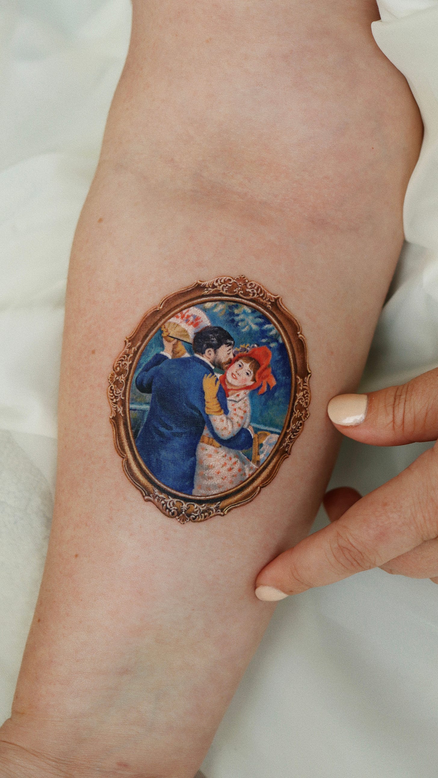 An artistic tattoo on an arm, illustrating a couple, with vibrant colors and detailed brushwork.
