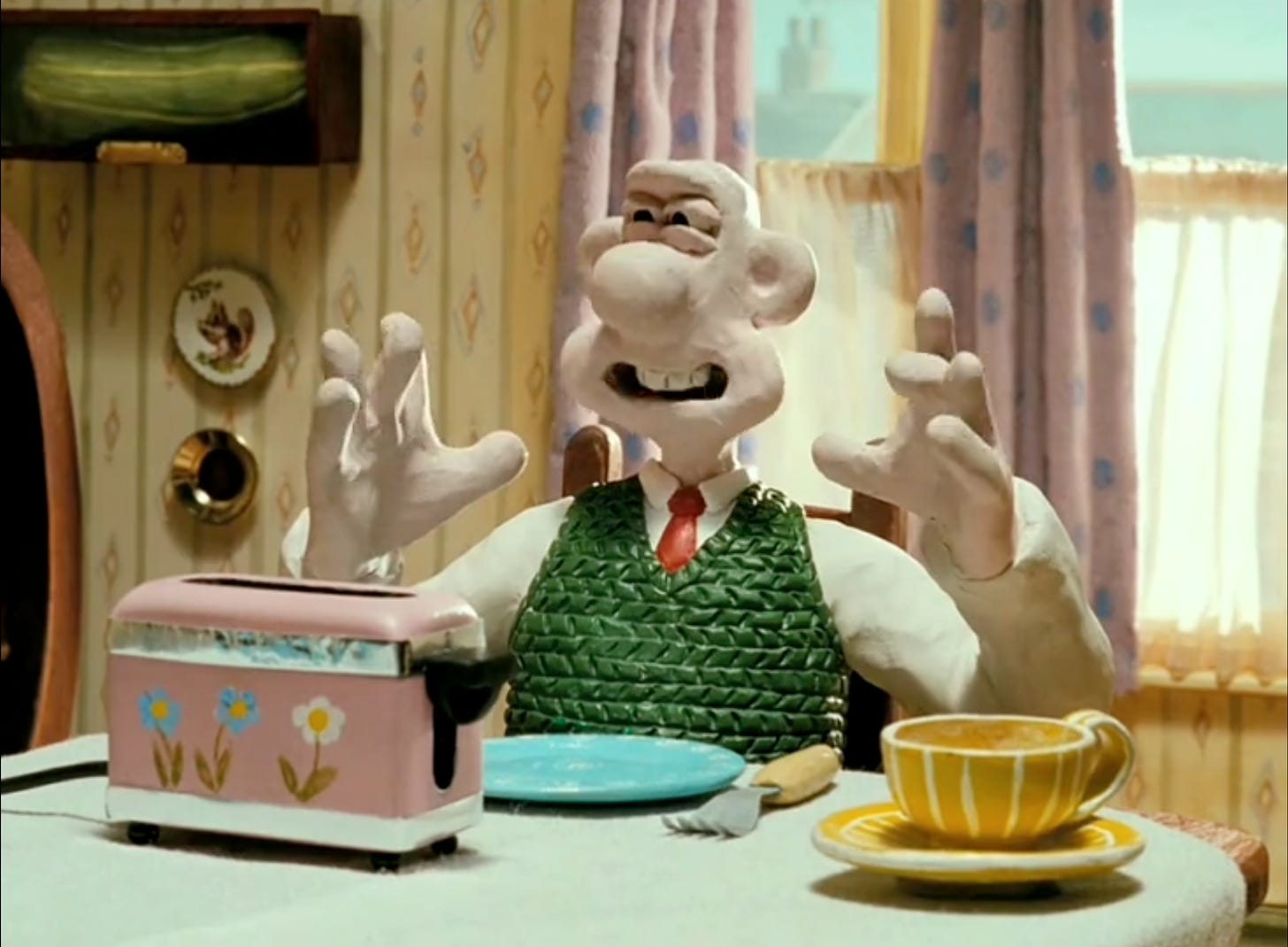 screenshot of Wallace from The Wrong Trousers, waggling his fingers as his is saying, "Crackin' toast, Gromit!"