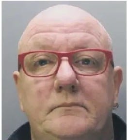 A bald person wearing red glasses

Description automatically generated