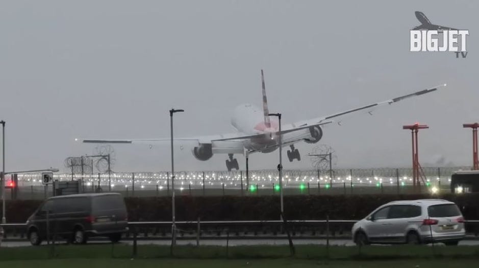 This is a screenshot from a video taken on the 28th of December 2023 at Heathrow Airport. The video, and the screenshot, are taken from outside the landing track, as a plane is approaching to land, and is pushed away by wind, making the plane tilt and bump as it tries to land. 