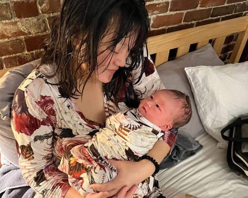 Katelin Potter holding her baby in bed.