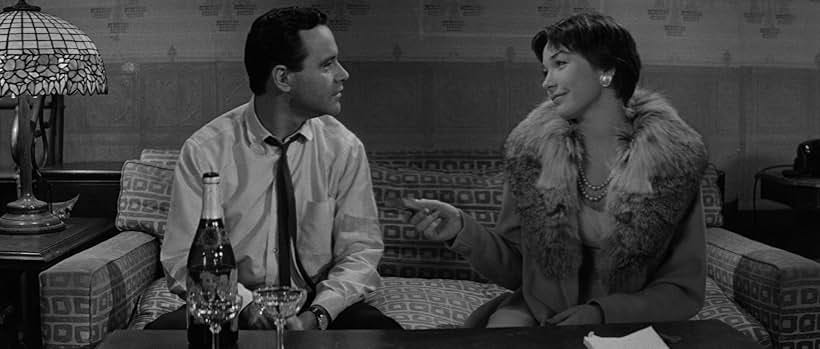 Jack Lemmon and Shirley MacLaine sit on the couch in The Apartment (1960)