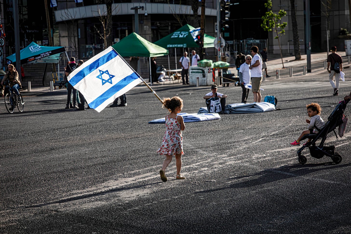  A girl walks with the Israeli flag prior to an anti-reform demonstration in Tel Aviv. (Photo by Eyal Warshavsky/SOPA Images/LightRocket via Getty Images.)