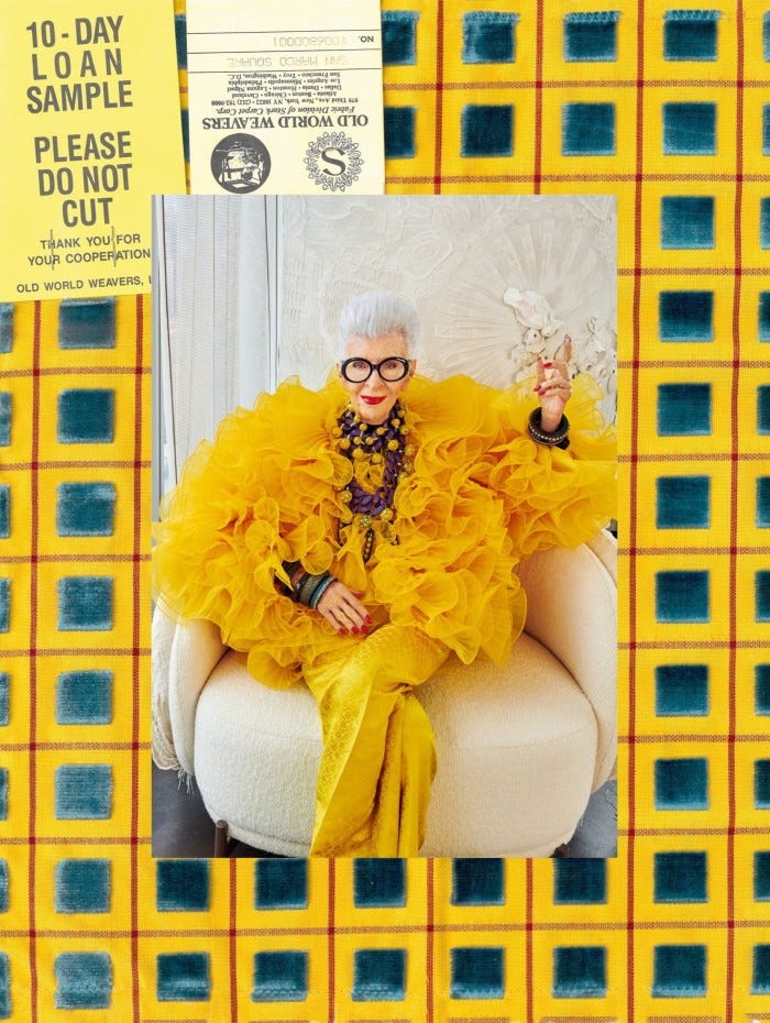 Iris Apfel wearing a ruffled yellow outfit 