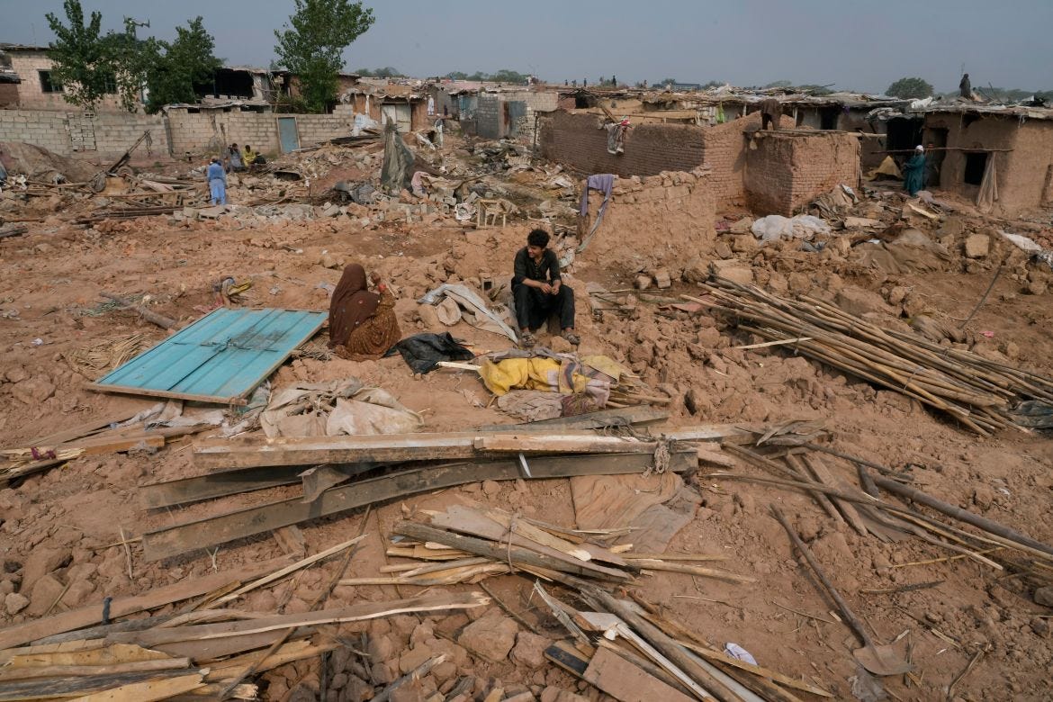 An Afghan family rests over the rubble as others retrieve useful stuff from their damage mud homes demolished by authorities during a crackdown against an illegal settlement and immigrants, on the outskirts of Islamabad, Pakistan.