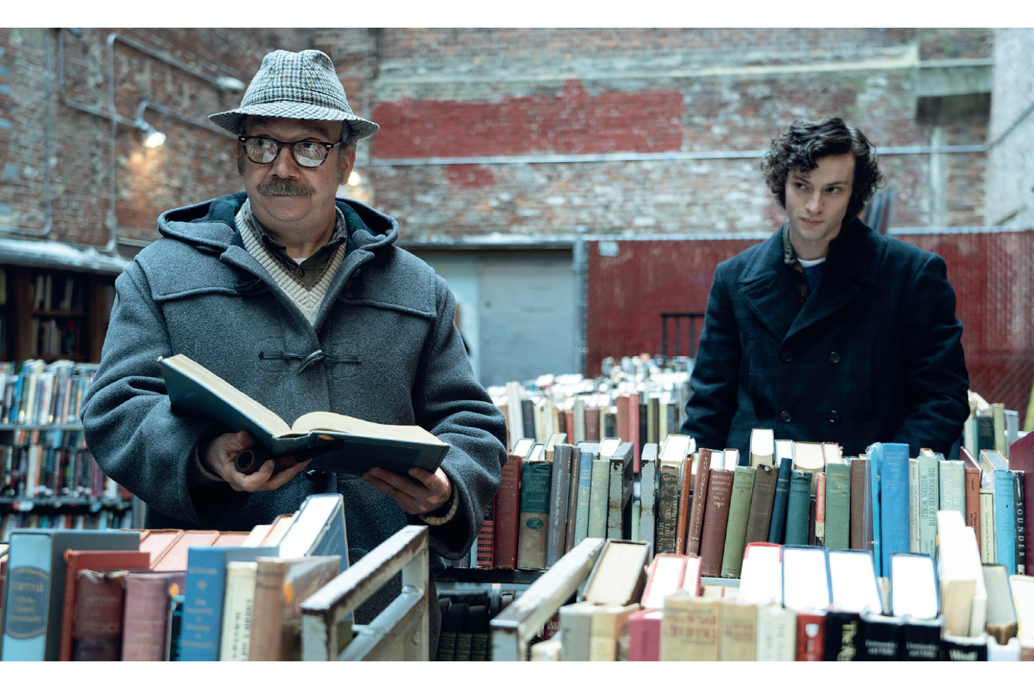 Movie still from The Holdovers. Two men stand in a bookstore.