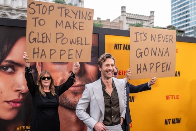 Glen Powell's Parents Showed Up on His Red Carpet With Signs Trolling Him:  'Stop Trying to Make Glen Powell Happen' and 'It's Never Gonna Happen'