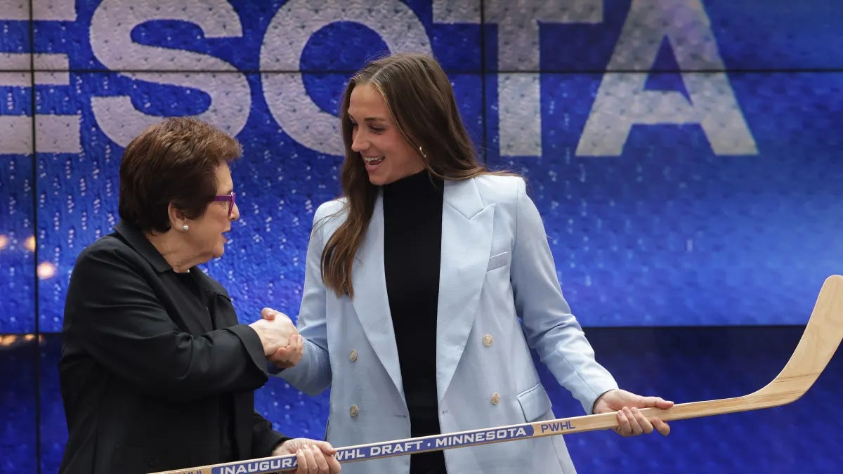 Taylor Heise and Billie Jean King shake handshakes on stage during the PWHL draft.