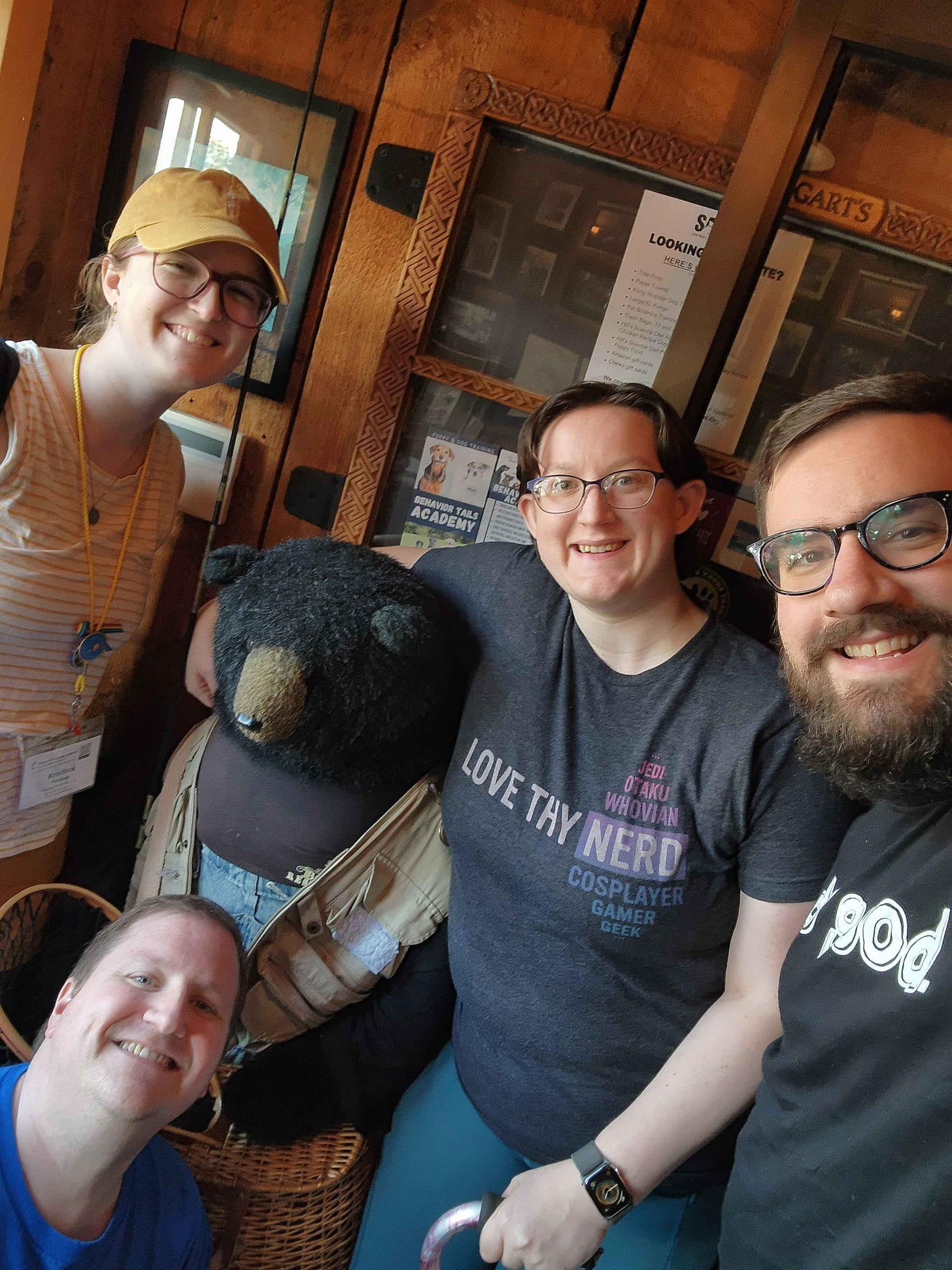 Tinikristinap, TromboneDalek, RainPlusCat, and Nerdpastornate standing with a stuffed bear at a restaurant