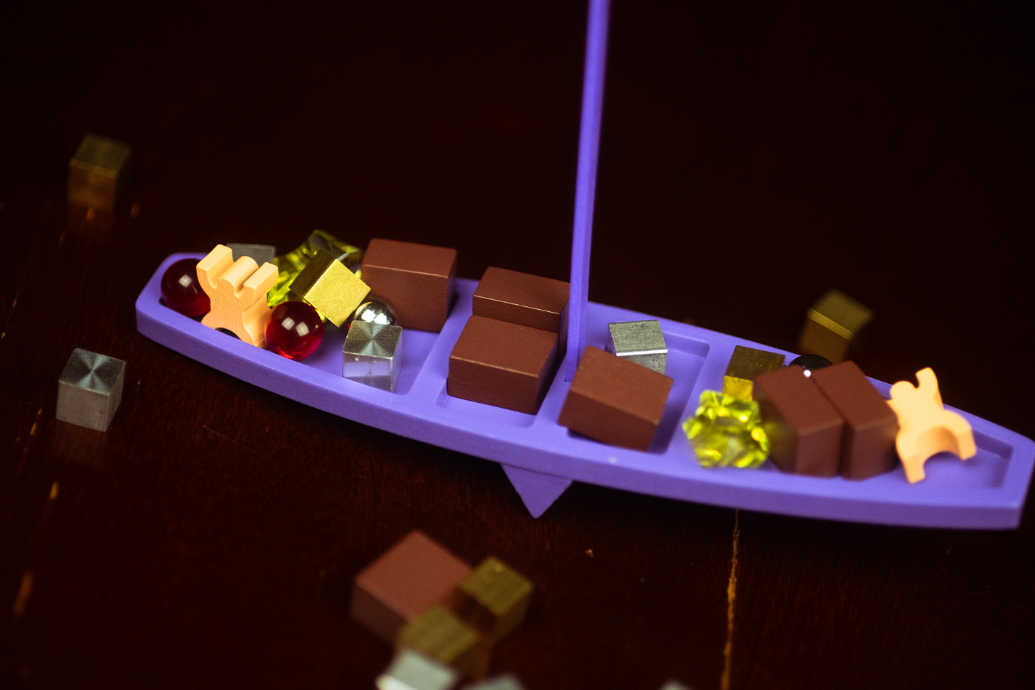 The board game Viking See-Saw, with many small pieces of cargo placed on a purple ship.