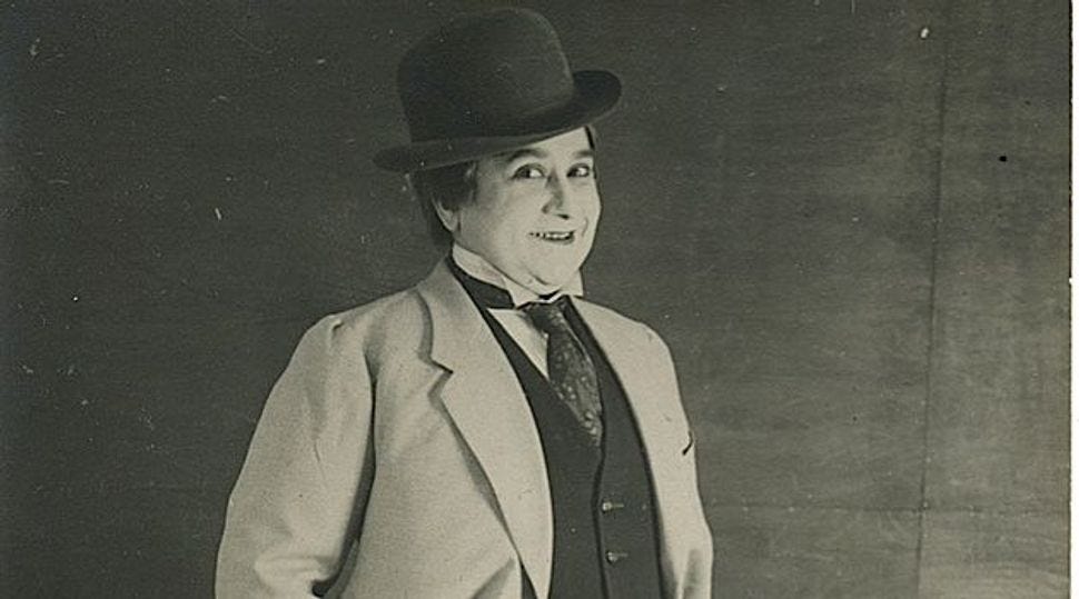 Black and white photo of a woman dressed in old timey men's clothing