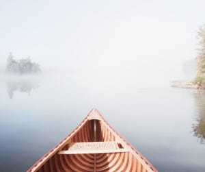 Bow of a canoe on the water in a northern lake.