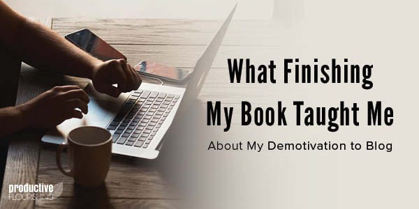 A person is typing on a laptop at their desk. Text overlay: What Finishing My Book Taught Me About My Demotivation to Blog