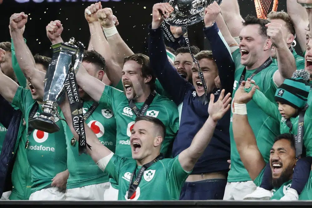 Ireland's Johnny Sexton, bottom center, holds the trophy as he celebrates with teammates at the end of the Six Nations rugby union international match between Ireland and England at the Aviva Stadium, in Dublin, Saturday, March 18, 2023. Ireland won the match 29-16 to clinch a grand slam and the Six Nations title. (AP Photo/Peter Morrison)