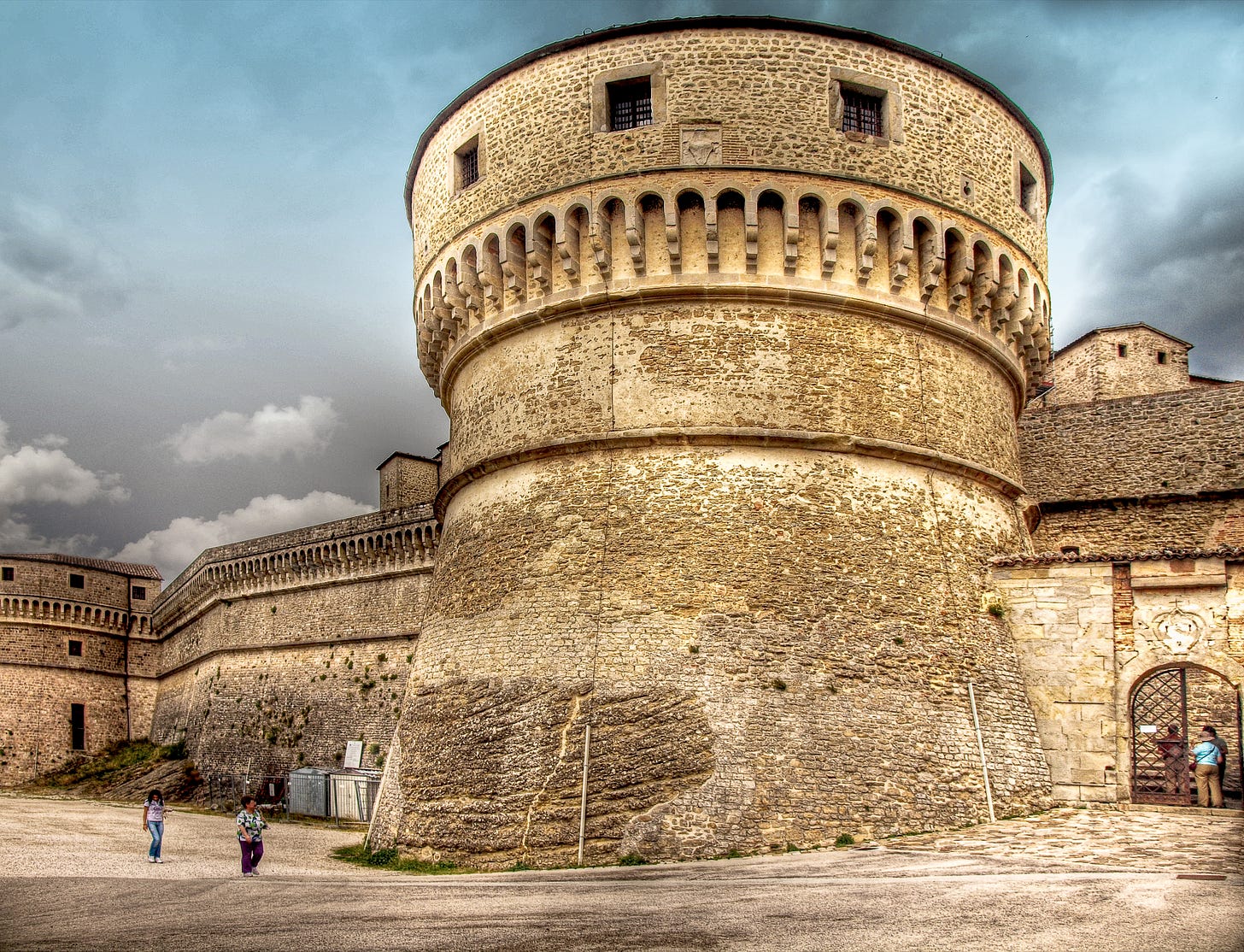 The round tower of the Fortress of San Leo built from stone bricks and natural rock.