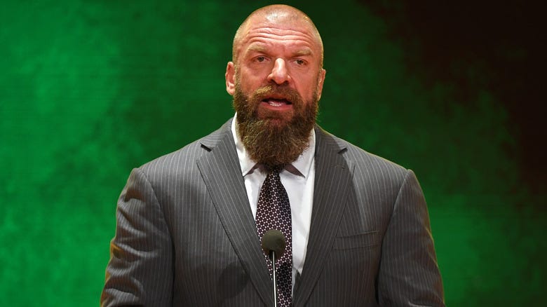 Triple H explaining something to a large rom of people