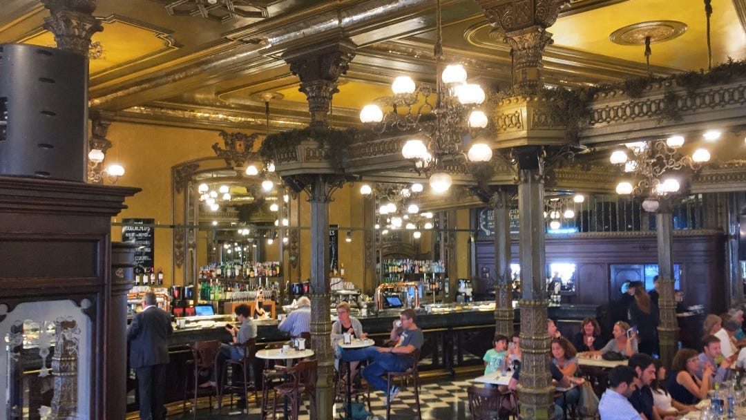 a glittery, golden colored 1920’s interior of a grand cafe