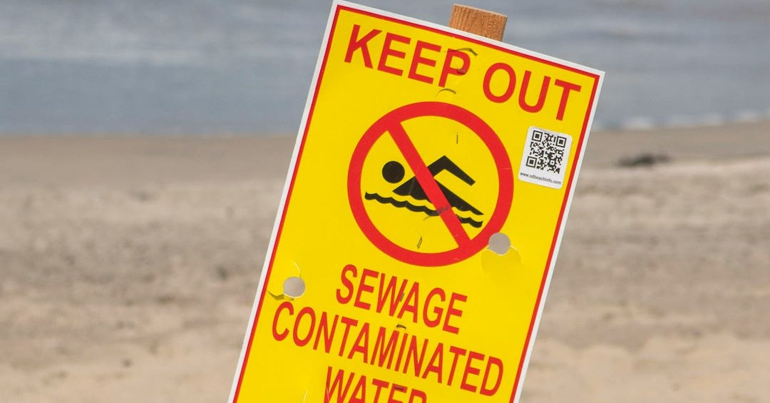 a yellow sign on a beach