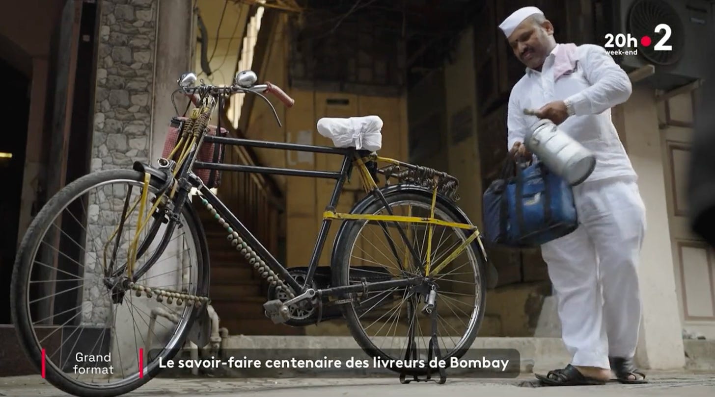 Livreur indien chargeant son vélo