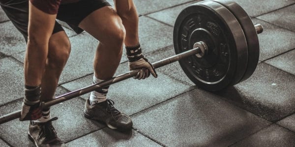 Person-with-proper-posture-Holding-Black-and-Silver-Steel-Barbell-ready-to-weighlift