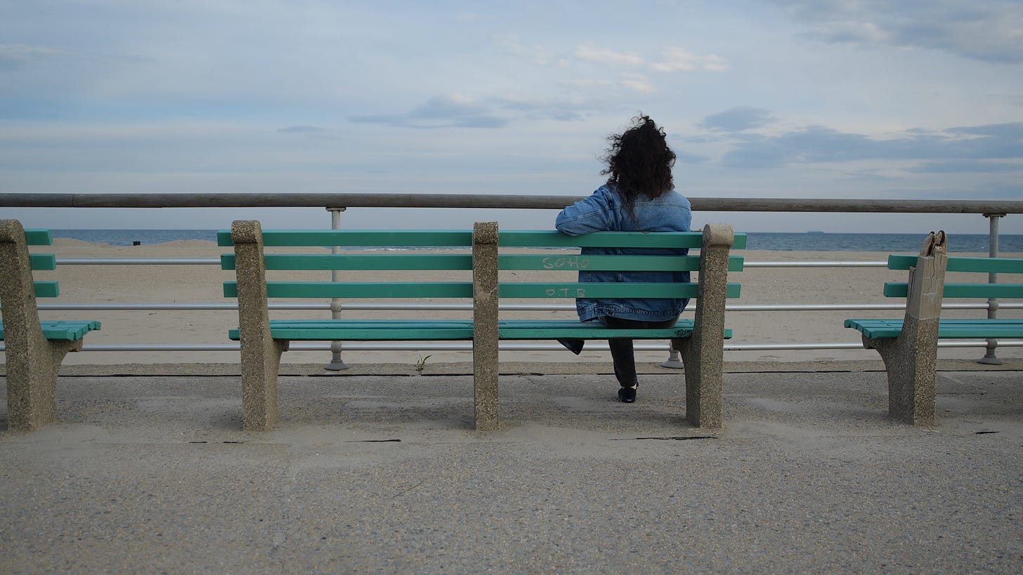 Lara Americo sits on a bench overlooking The People's Beach in Jacob Riis Park.