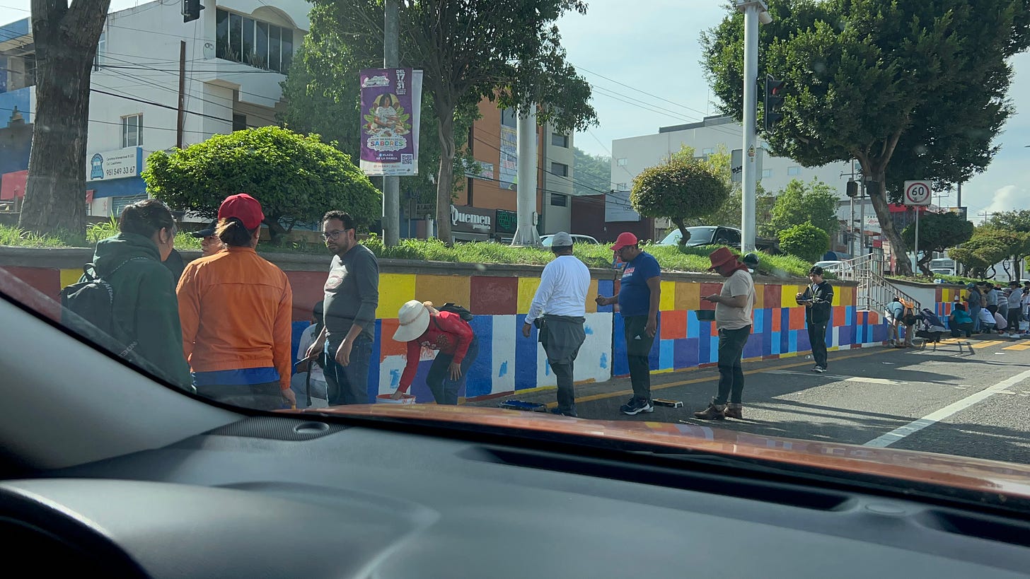 Tequio members painting designs on the highway median.