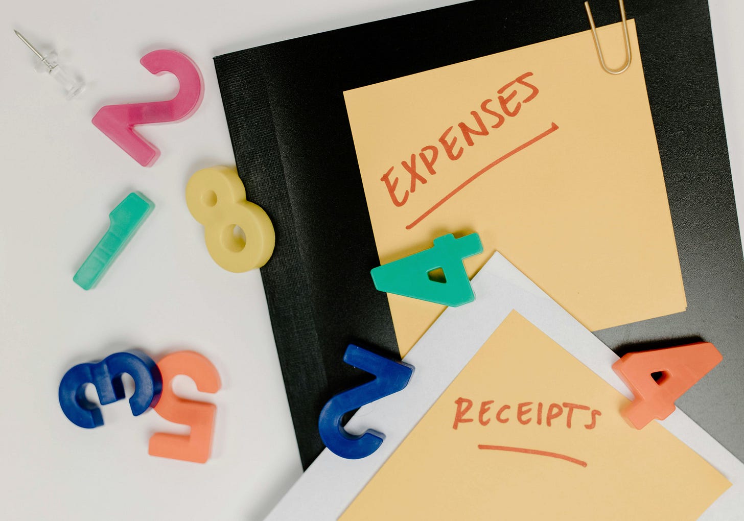 A notebook with sticky notes saying "expenses" and "receipts".