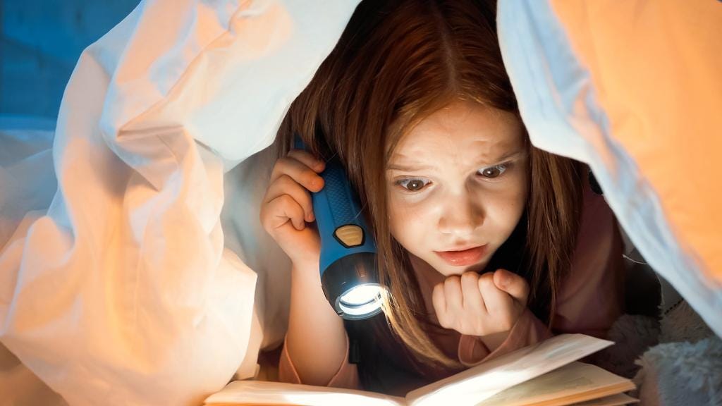 Concentrated Kid With Flashlight Reading Book On Free Stock Photo and Image  468532422