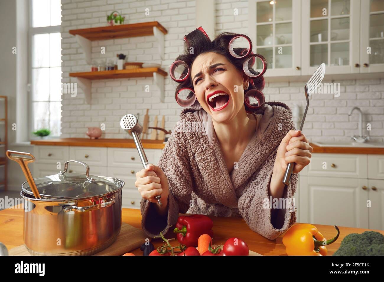 Unhappy young housewife sick and tired of cooking and housework crying in  the kitchen Stock Photo - Alamy