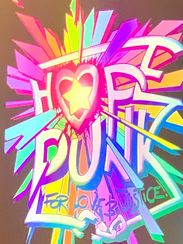 Brightly colourful street art with the words 'Hope' and 'Punk' surrounded by a rainbow starburst; at the bottom it says 'for love and justice'.