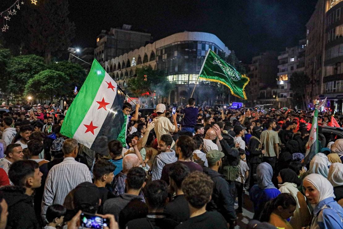 Syrians wave Saudi and Syrian flags in celebration after President Donald Trump announced plans during his visit to Saudi Arabia to ease sanctions on Syria and normalize relations with its new government, in Homs, Syria, on May 13. Syrians wave Saudi and Syrian flags in celebration after President Donald Trump announced plans during his visit to Saudi Arabia to ease sanctions on Syria and normalize relations with its new government, in Homs, Syria, on May 13.