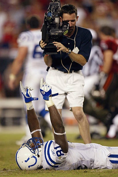 Camerman moves in on tight end Marcus Pollard of the Indianapolis Colts puts his arms up in the air to celebrate a Colt's victory against the Tampa...