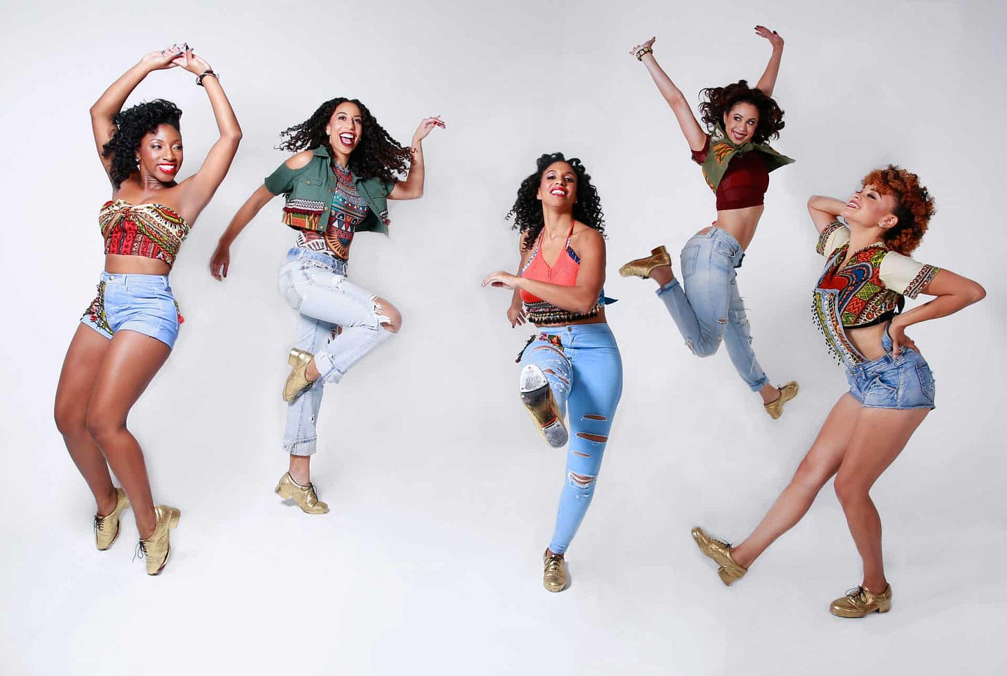 5 women dance in the Syncopated Ladies, the women are in motion and some are dancing, some are jumping