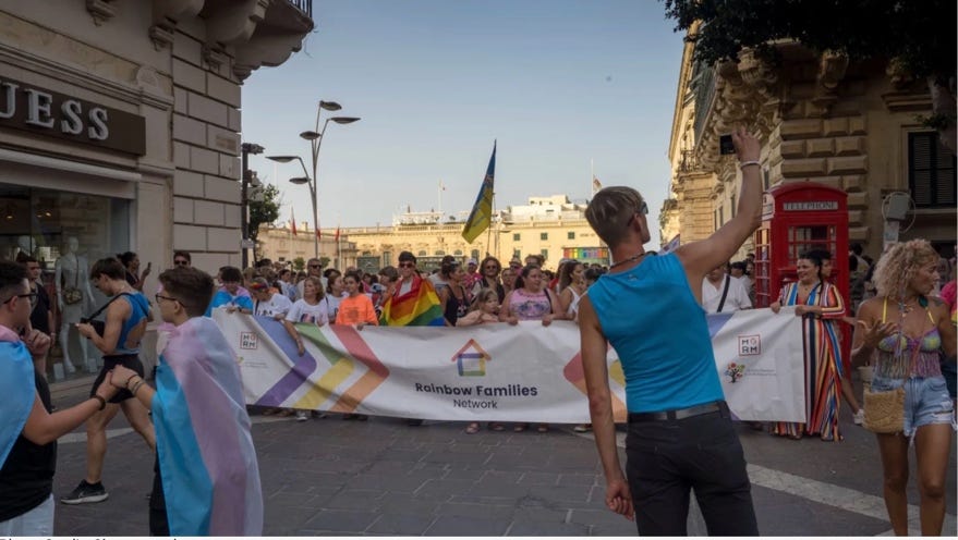 A person holding a sign in front of a crowd

Description automatically generated