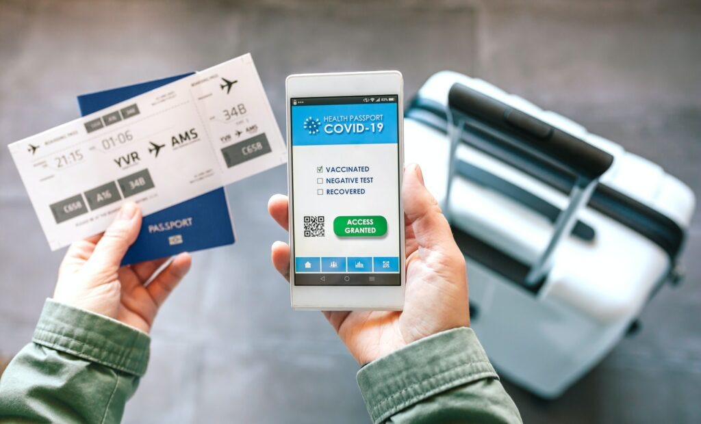 Hands holding a mobile with covid passport and boarding pass