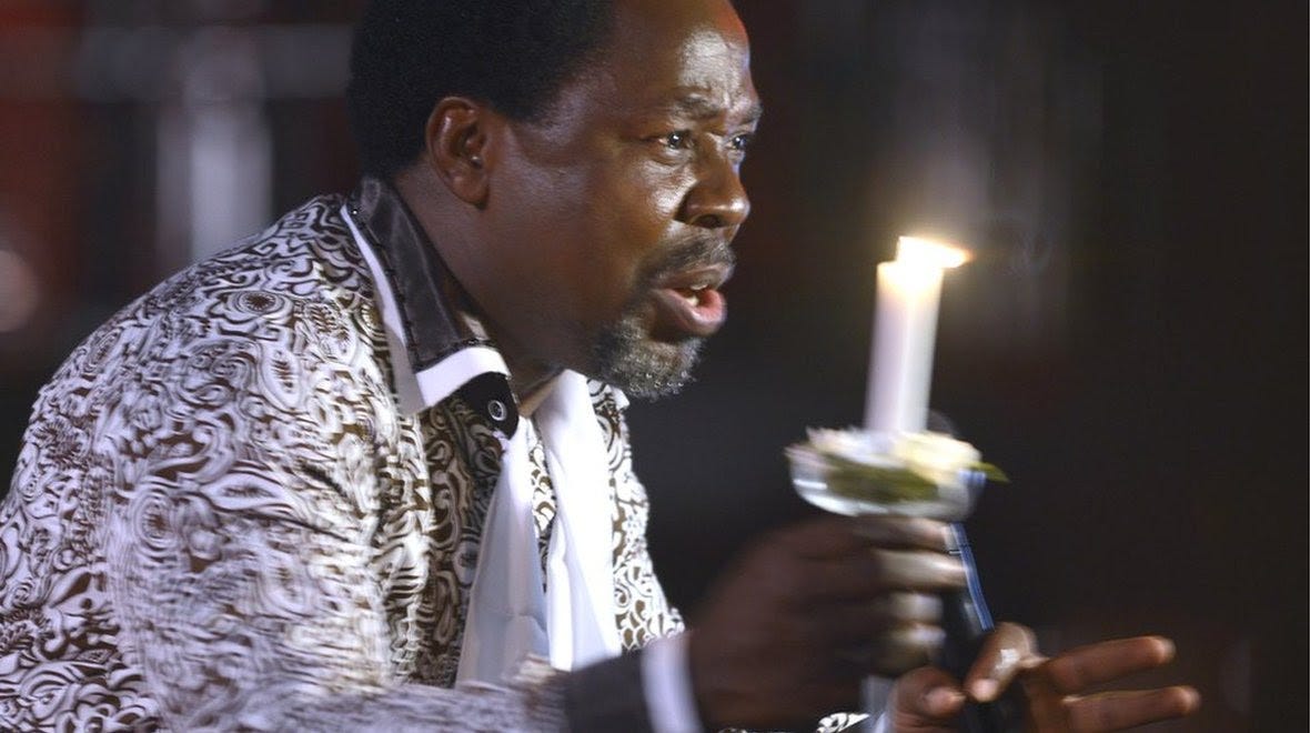 Nigerian pastor TB Joshua holds a candle while preaching in 2014