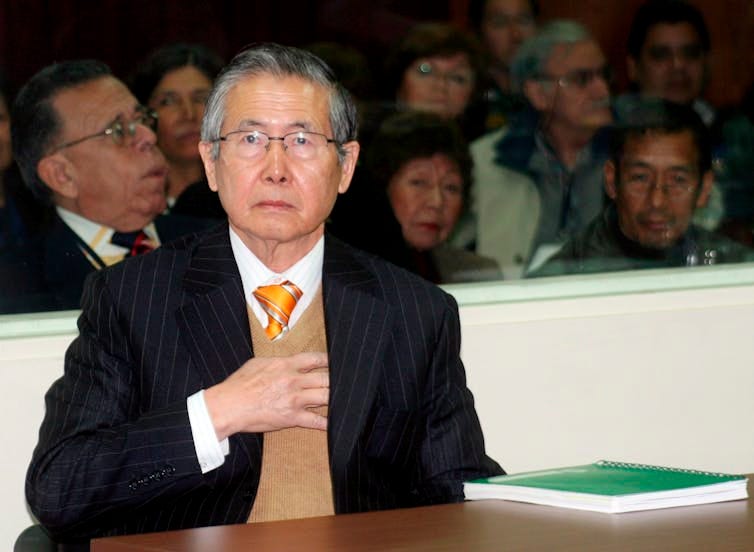 Alberto Fujimori sat in court wearing a suit.