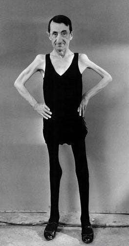 A man poses in leggings and a vest in a promotional photo taken for a human circus A man poses in leggings and a vest in a promotional photo taken for a human circus