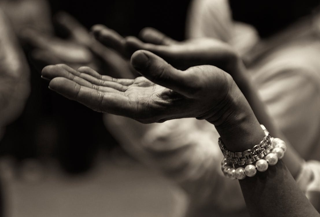 Free Close-up of expressive hands in prayer wearing a bracelet, conveying faith and devotion. Stock Photo