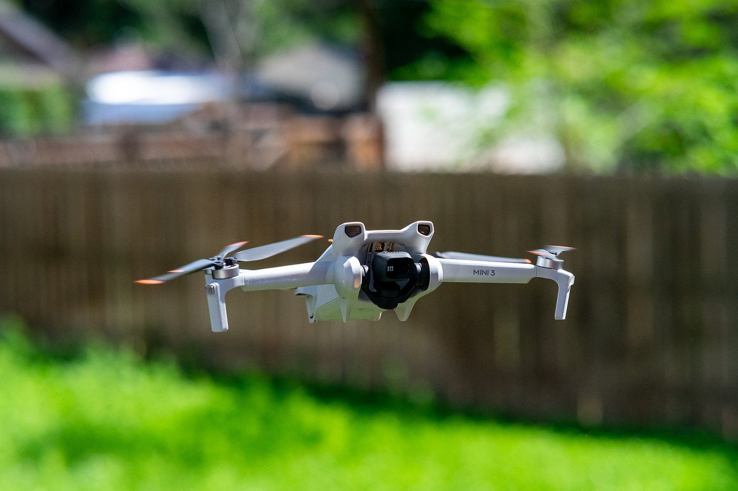 DJI Mini 3 drone in flight capturing a scenic landscape.