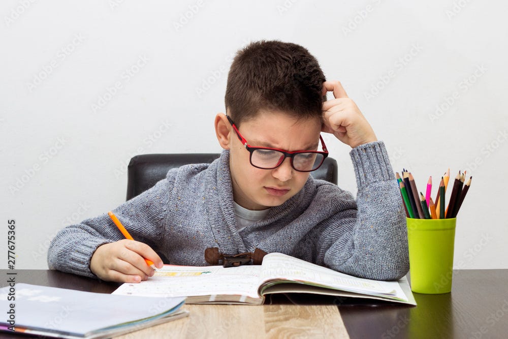 Young boy frustrated over homework, writing at home. Boy studying at table.  Kid drawing with a pencil Stock Photo | Adobe Stock