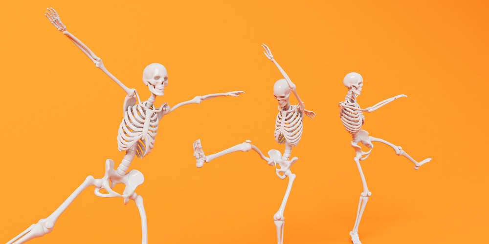 Joyful, dancing skeletons across an orange background. The revelry of the dead.