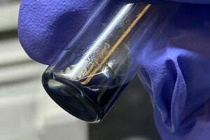 The purple/blue solution in this vial contains crystals of the berkelocene “sandwich.”