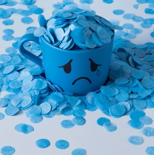 Blue monday with paper rain and crying mug