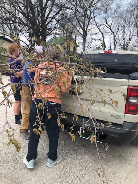 A group of people standing next to a tree branch

AI-generated content may be incorrect.