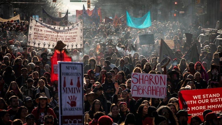 A large crowd holding signs.