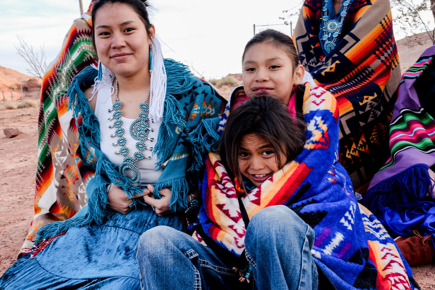 A Native American family sits together.