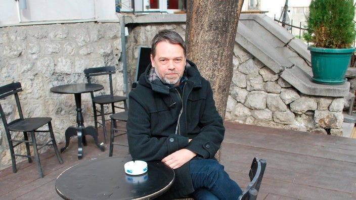 Srdjaan Koljevic einem Tisch auf einer Terrasse