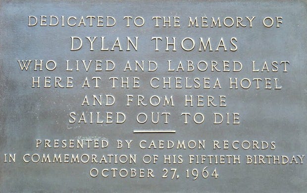 A rectangular plaque in roman upper case font that reads: Dedicated to the memory of Dylan Thomas who lived and labored last here at the Chelsea Hotel and from here sailed out to die. Presented by Caedmon Records in commemoration of his fiftieth birthday, October 27th 1964