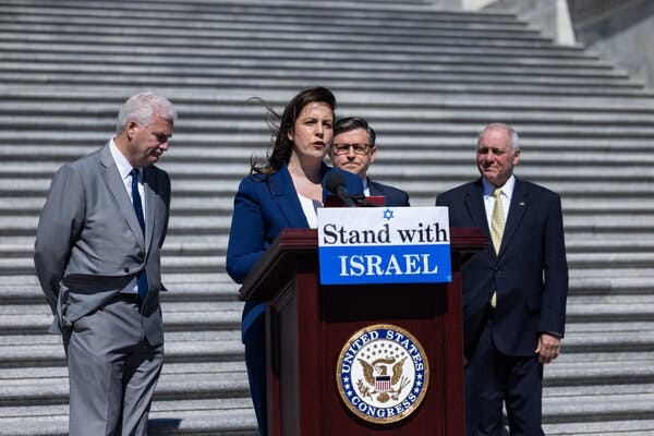 Ms. Stefanik at the Capitol, at a podium with a sign reading “Stand with ISRAEL.”